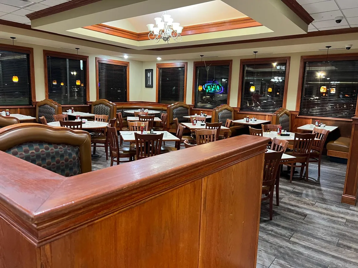 Booths and tables beneath a chandelier in the main dining room